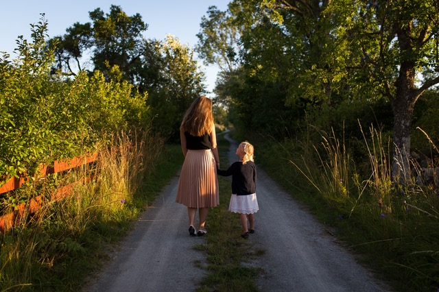 mom and daughter walking down country lane